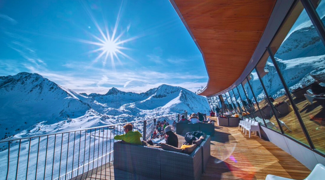 Na imagem, é possível observar pessoas na esplanada de um restaurante em Grandvalira a observarem as montanhas com neve.