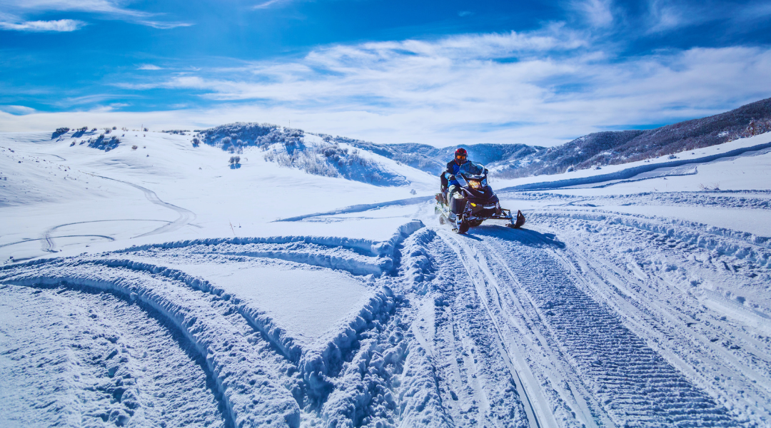 Nesta imagem, é possível observar uma pessoa a praticar snowmobiling na neve em Grandavalira. 