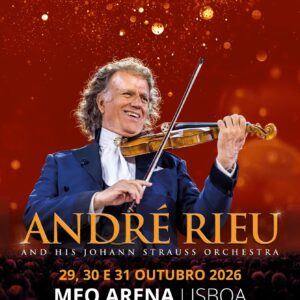 Violinist Andre Rieu performing on stage with a smile, playing his violin against a red/orange backdrop and concert text beneath.